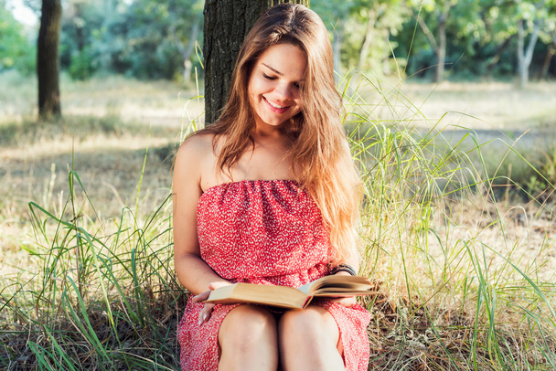 young beautiful caucasian female reading book in park - Fotografie, Obrázek