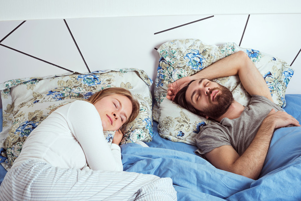young caucasian couple sleeping in bed - Foto, afbeelding