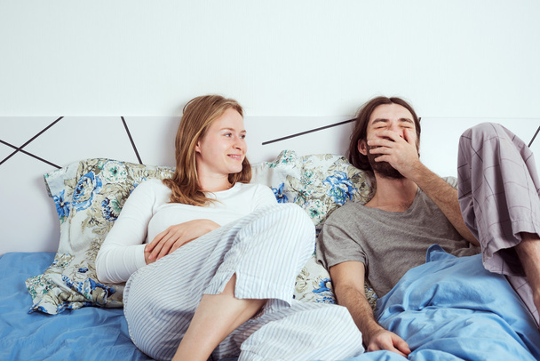 young loving couple smiling and talking in bed - Fotoğraf, Görsel