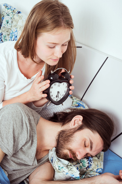 young caucasian couple in bed with alarm clock - Φωτογραφία, εικόνα