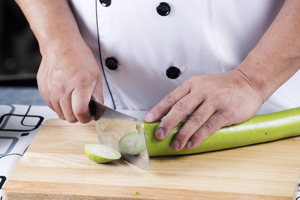 Chef-kok snijden groene aubergine - Foto, afbeelding