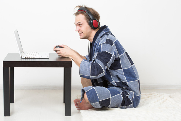 man in bathrobe playing on a laptop - Foto, afbeelding