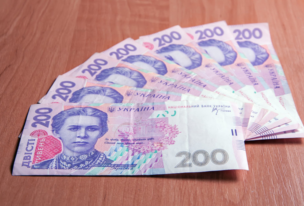Oekraïense bankbiljetten voor twee honderd hryvnias op een houten tafel - Foto, afbeelding