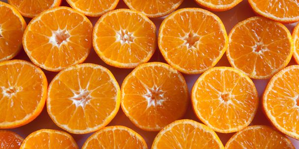 Orangengeschnittene Mandarinen auf einem Tisch als Hintergrund - Foto, Bild