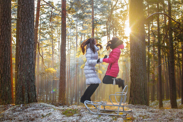 Dos chicas saltan en el bosque de invierno
. - Foto, Imagen