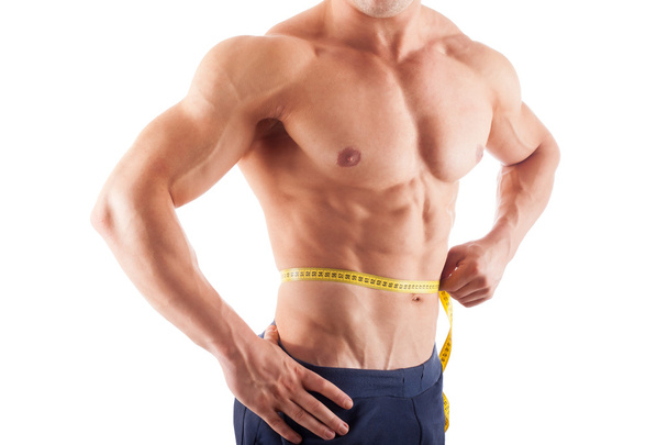 Hombre musculoso midiendo su cintura
 - Foto, Imagen