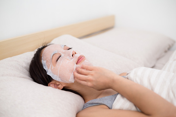 woman doing facial paper mask - Fotó, kép