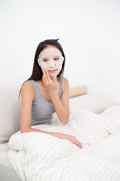 woman doing facial paper mask - Фото, изображение