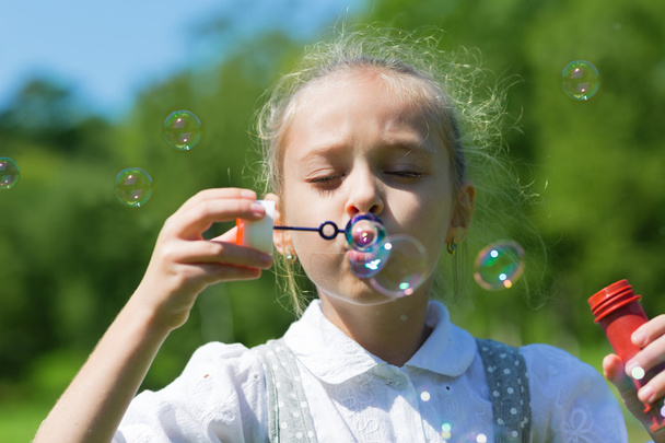 Милая девушка, пускающая мыльные пузыри - Фото, изображение