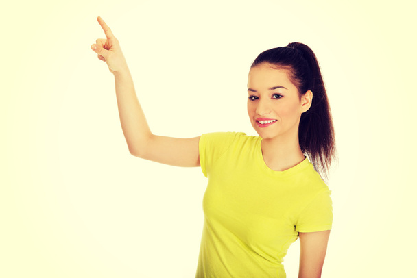 Young woman pointing up. - Fotó, kép