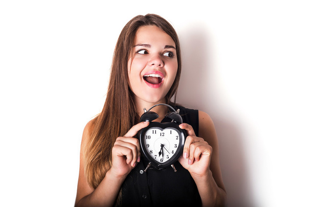smiley businesswoman holding alarm clock. isolated on white back - Foto, afbeelding