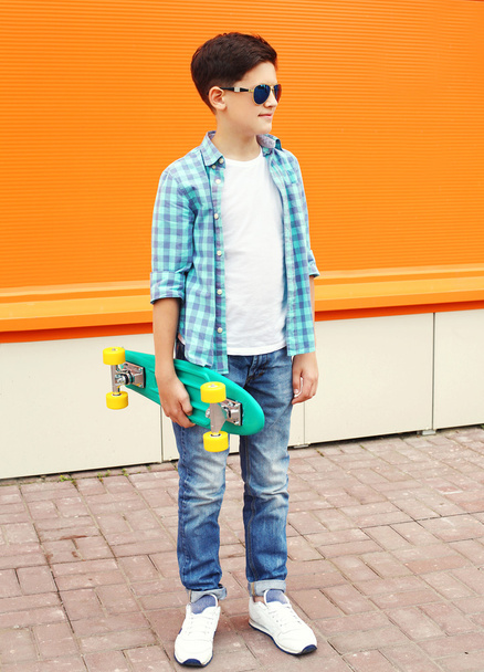 Fashion teenager boy wearing a shirt, sunglasses and skateboard - Valokuva, kuva