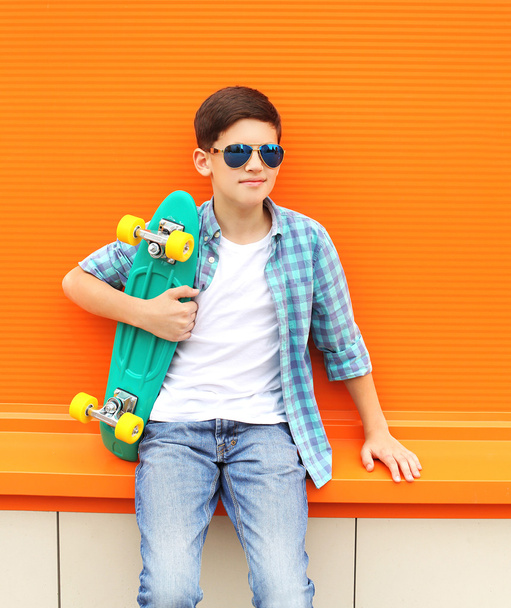 Stylish teenager boy wearing a checkered shirt, sunglasses and s - 写真・画像