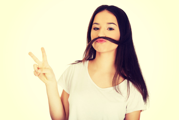 Teen woman putting hair like moustache. - Photo, Image