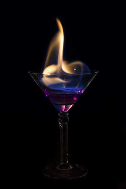 Martini glass with purple drink is on fire and very hot - Foto, Bild