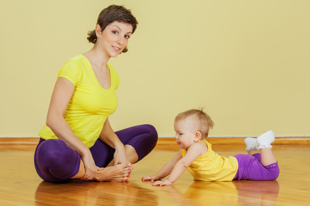 Mother does physical exercises with her daughter at home - Fotó, kép