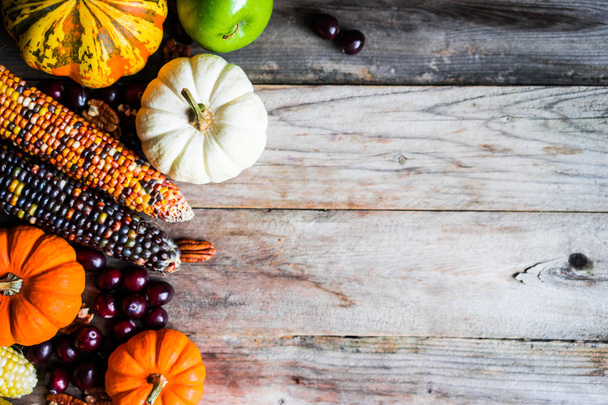 Pumpkins,corn,apples,nuts and cranberries on wooden background - Fotografie, Obrázek