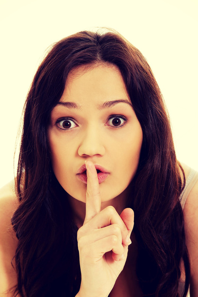 Young woman with finger on lips. - Foto, imagen