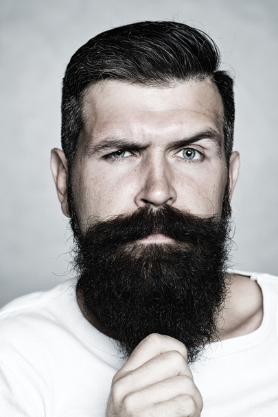 Grey-haired man pulling beard - Fotoğraf, Görsel