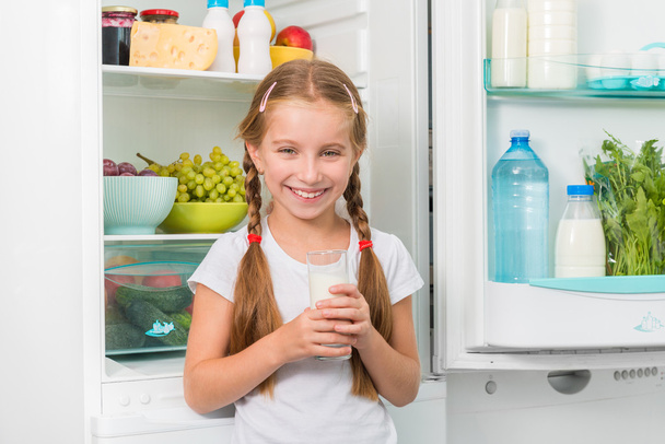 little girl holding a glass of milk - Foto, Imagen