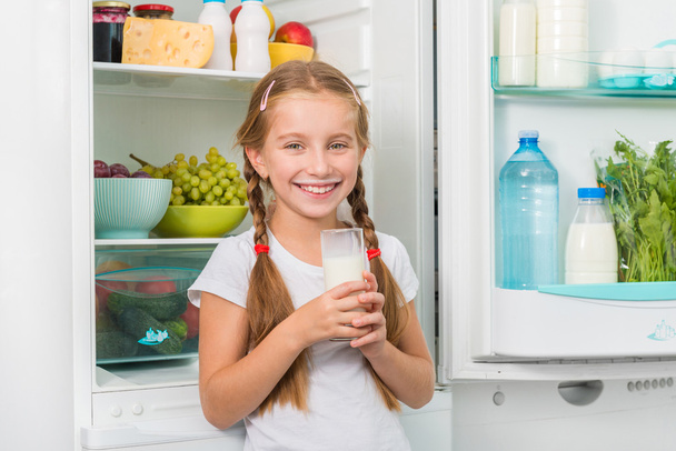 little girl holding a glass of milk - Foto, Bild