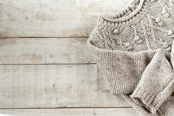 knitted pullover on wooden boards with copy space for text. - 写真・画像