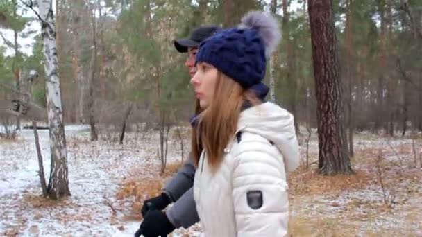 νεαρό ζευγάρι περπάτημα στο δάσος στο πρώτο χιόνι - Πλάνα, βίντεο