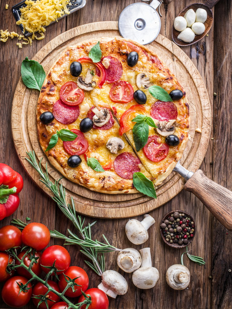 Pizza with mushrooms, salami and tomatoes. - Foto, afbeelding