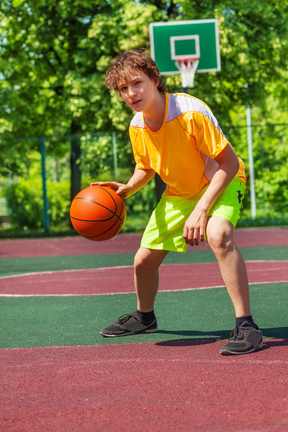 Garçon jouer avec la balle seul pendant le match de basket
 - Photo, image
