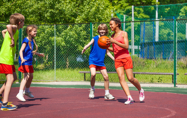 African girl holds ball and teens play basketball - Foto, Imagem