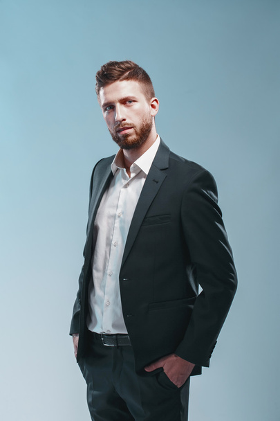 Studio shot of a stylish bearded man in elegant suit, colored tiffany background, isolate - Fotoğraf, Görsel