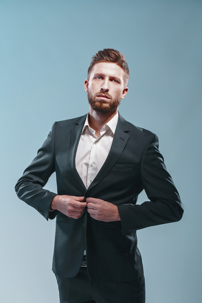 Studio shot of a stylish bearded man in elegant suit, colored tiffany background, isolate - Foto, Imagen