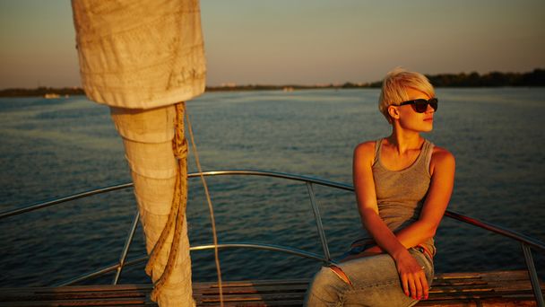 Woman traveling by boat at sunset - Zdjęcie, obraz