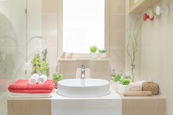 Lavabo avec serviette et décoration dans la salle de bain
 - Photo, image