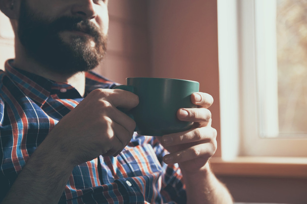 man sitting with cup of coffee - Фото, зображення