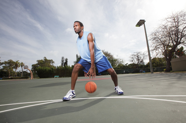 Jugador de baloncesto driblando la pelota
 - Foto, Imagen