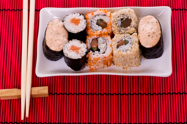 Set di involtini di sushi sul piatto bianco con fiori
 - Foto, immagini