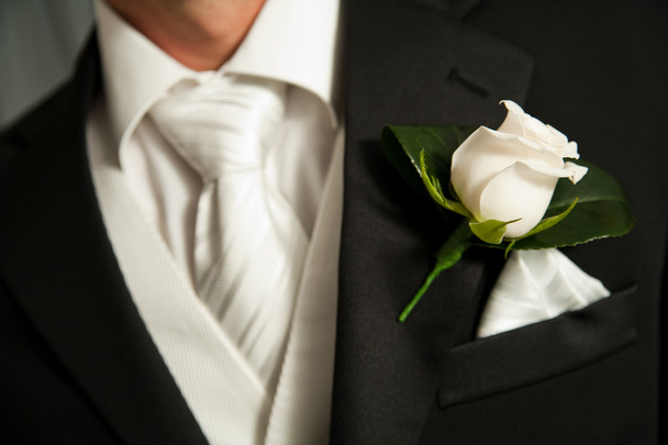 Close up van een witte roos corsage op een bruidegom - Foto, afbeelding