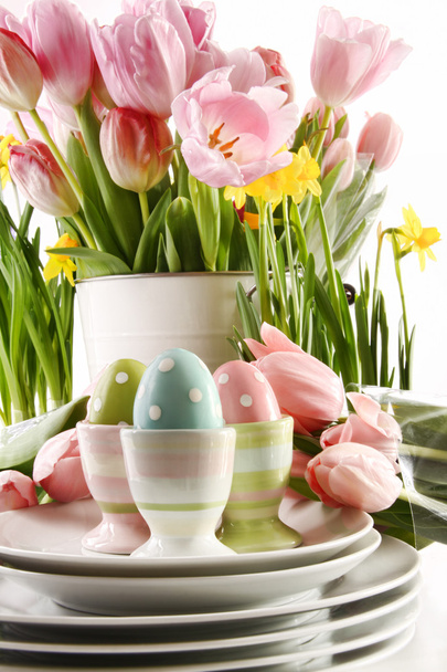 Œufs de Pâques dans des tasses avec des fleurs de printemps sur blanc
 - Photo, image