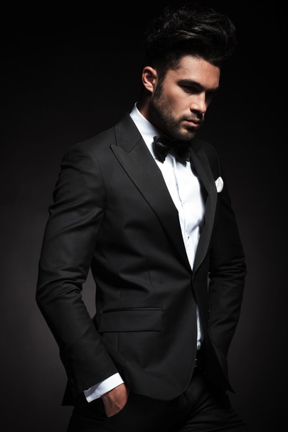 elegante hombre de negocios posando sobre fondo negro
 - Foto, Imagen