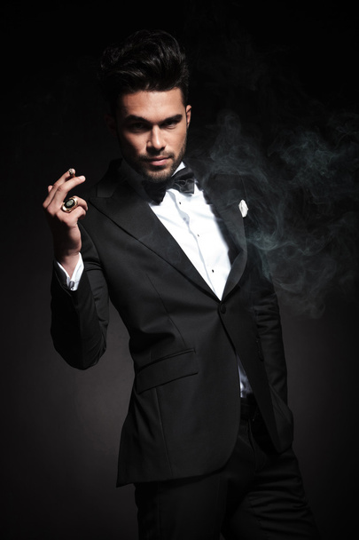 Красивый молодой бизнесмен наслаждается сигаретой
 - Фото, изображение