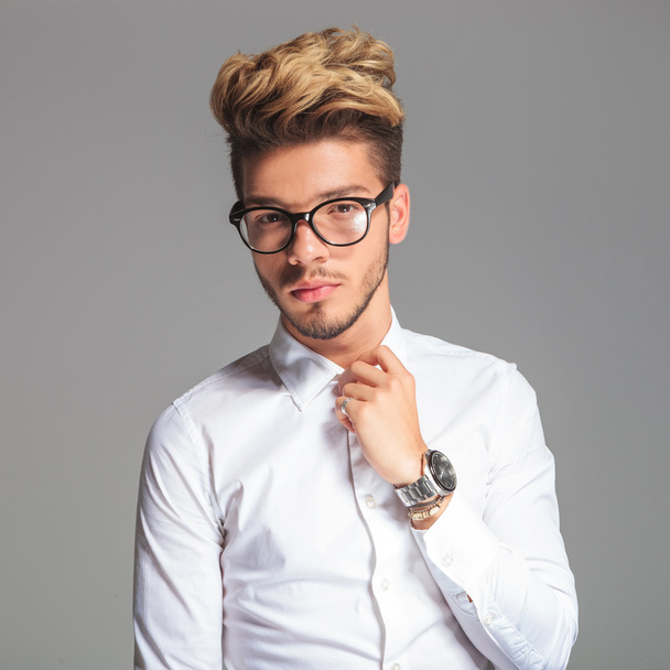 student wearing glasses while posing and fixing his shirt - Foto, Imagen
