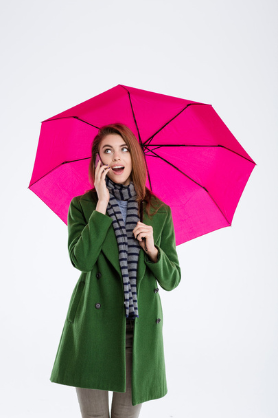 Woman holding umbrella and talking on the phone - Foto, Imagen