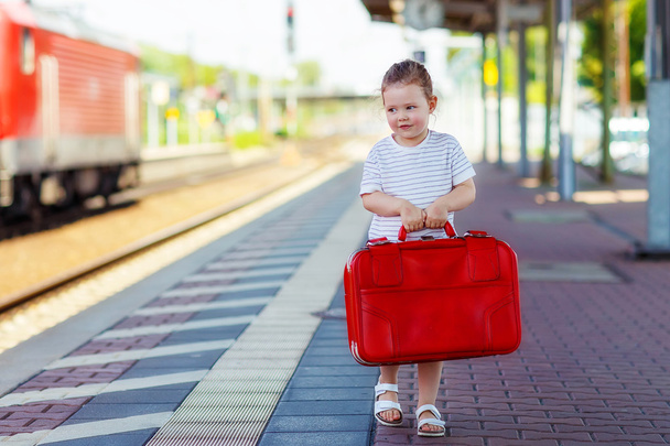 Χαριτωμένο μικρό κορίτσι σε ένα σιδηροδρομικό σταθμό. - Φωτογραφία, εικόνα