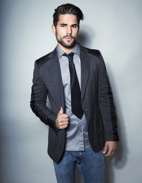 schöner junger Mann im Anzug auf grauem Hintergrund - Foto, Bild
