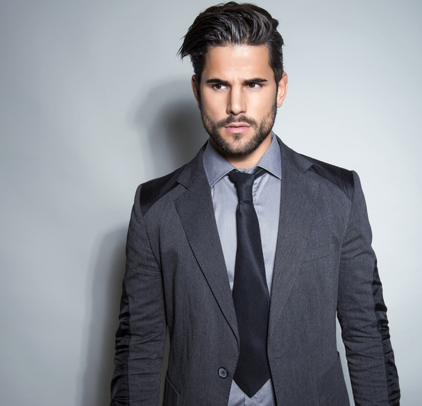 handsome young man in suit on grey background - Photo, Image