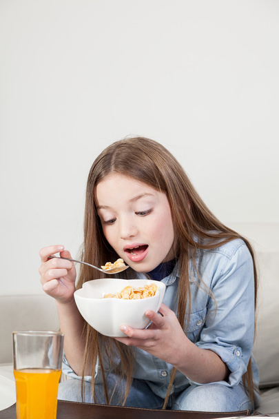 Little girl eating cereal - Фото, зображення