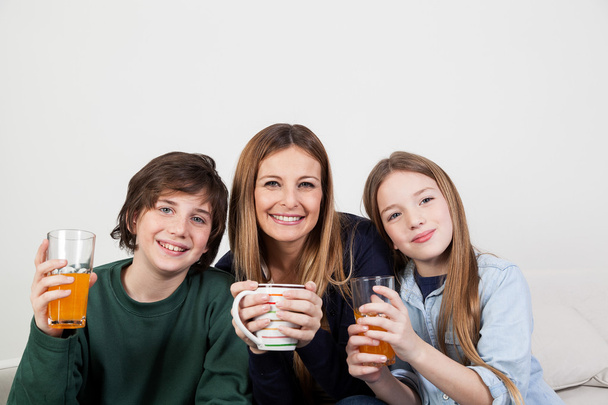 Mutter mit Sohn und Tochter trinken Saft - Foto, Bild