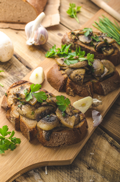 Mushroom mixture on rustic toast with garlic - Foto, Imagen