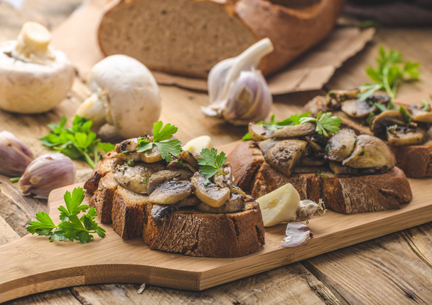 Mushroom mixture on rustic toast with garlic - Foto, afbeelding